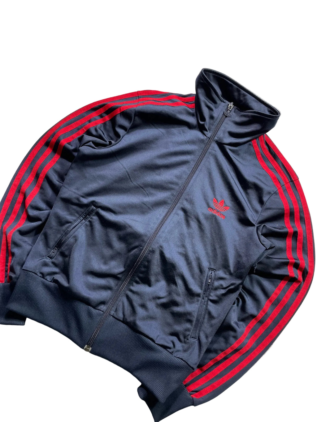 Schnell Spart adidas Trainingsjacke in Dunkelblau mit roten Drei-Streifen, Stehkragen und Trefoil-Logo auf der Brust.