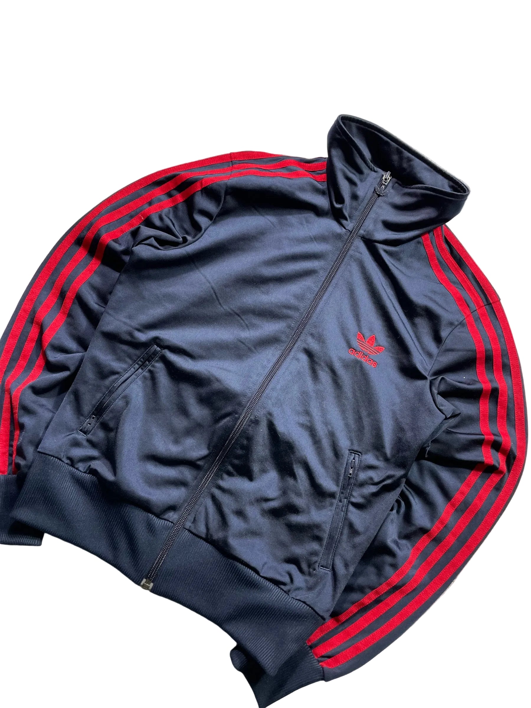 Schnell Spart adidas Trainingsjacke in Dunkelblau mit roten Drei-Streifen, Stehkragen und Trefoil-Logo auf der Brust.